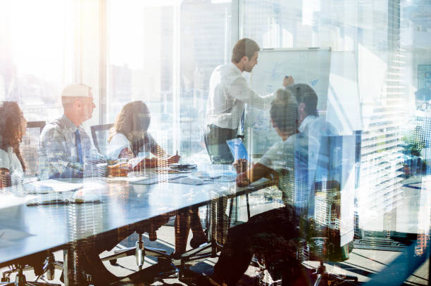 montage of a team of business people at a presentation at the boardroom table. - mobiles internet imagens e fotografias de stock