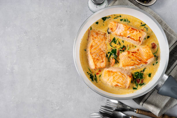 istock Delicious salmon peaces in cream sauce on light background 1197946397