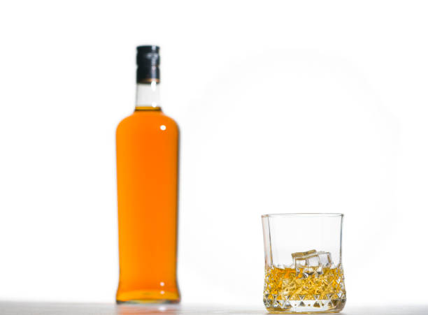 Whiskey in Crystal Tumbler with Bottle and White Background