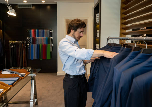 istock Young male customer looking at suits at a men's store 1197952532