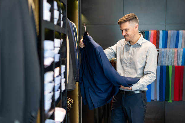 istock Handsome young man looking for suits at a men's clothing store 1197952649