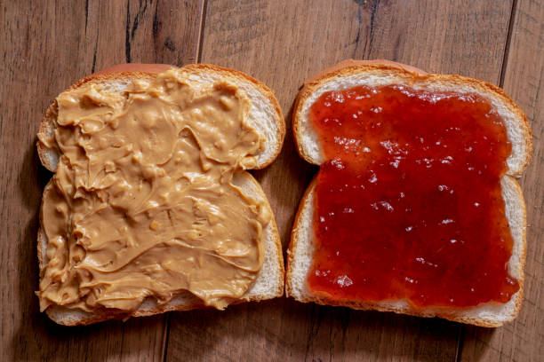 istock Open Face Peanut Butter and Jelly Sandwich on a Rustic Cutting Board 1197953303