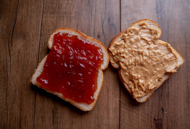 istock Open Face Peanut Butter and Jelly Sandwich on a Rustic Cutting Board on Artisan Multi-Grain Bread 1197953306