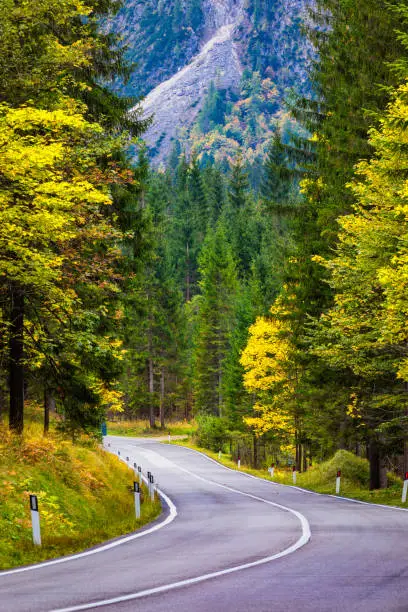 Photo of Mountain road. Landscape with rocks, sunny sky with clouds and beautiful asphalt road in the evening in summer. Vintage toning. Travel background. Highway in mountains.