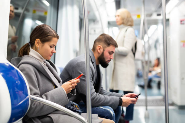 istock Man and woman using phone inside subway 1197954916