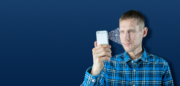 man using his phone to  face identification and authorization, security of personal data