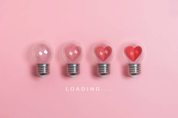 istock Red hearts in light bulbs. Loading progress bar on pink background. 1197961943