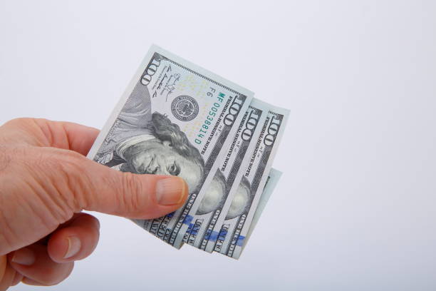 istock View of hand in held 100 dollar banknotes. 1197962640
