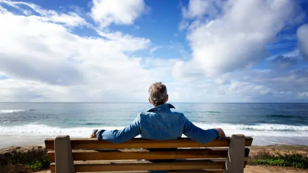 Photo of La Jolla, CA: Man Sitting on Bench Looking at Pacific Ocean