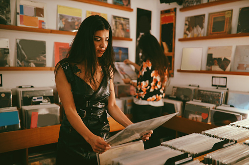 Young woman looking through records at a vinyl shop, Buenos Aires, Argentina.