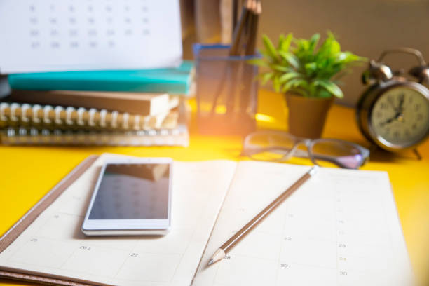 Diary,Calendar and agenda for Planner to plan timetable,appointment,organization,management on table.Desktop Calender 2020 and smart phone place on wooden office desk.Calendar Background Concept.