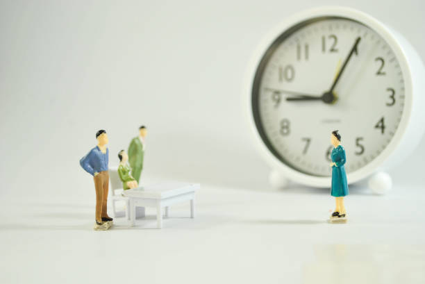 Miniature human figure on the clock and white background