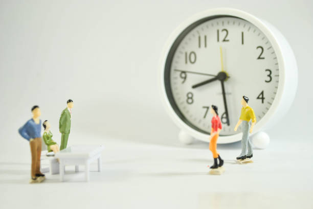 istock Miniature human figure on the clock and white background 1197974711