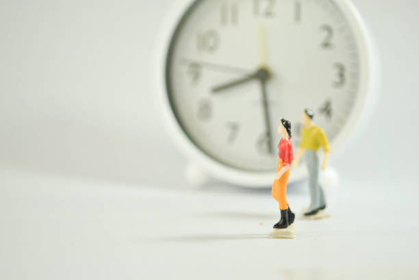 istock Miniature human figure on the clock and white background 1197974712
