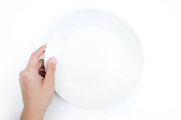 istock Top view, hand holding a white plate on a white background, Close up. Isolated background. 1197976304