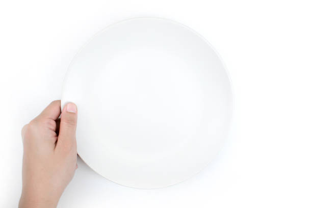 istock Close-up, one hand holding the white plate on isolated background. 1197976347