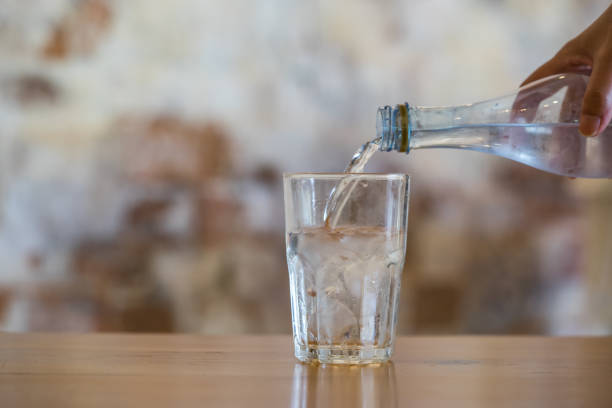 istock Pouring water from bottle into glass 1197979826