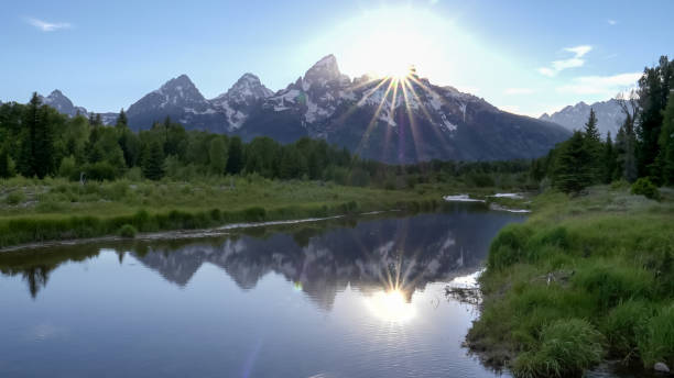 istock sun setting behind grand teton from schwabachers landing 1197982464