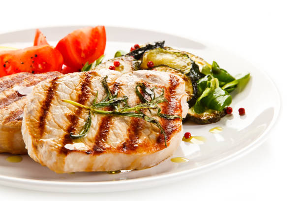 istock Grilled pork steak with vegetables on white background 1197983265