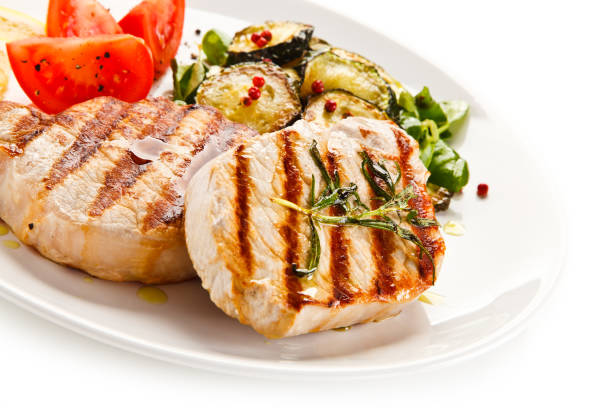 istock Grilled pork steak with vegetables on white background 1197983281