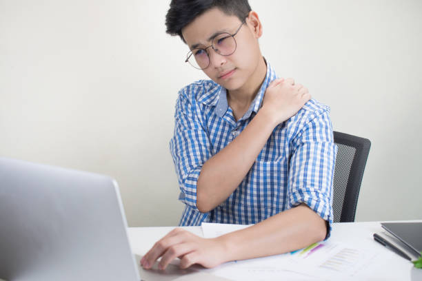 young business people have shoulder and back pain sitting on the desk - physical injury backache occupation working imagens e fotografias de stock