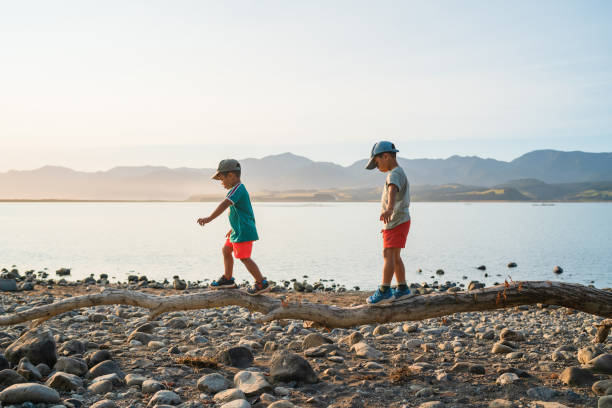 Kids walking on log trying to balance.