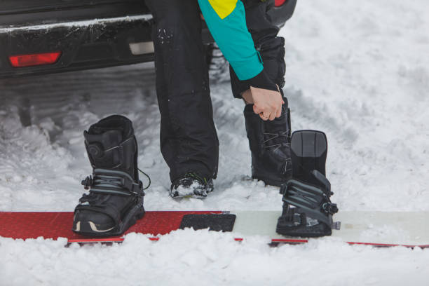 남자는 자동차 근처 주차장에서 스노우 보드에 일반 부츠를 변경 - snowboard boot 뉴스 사진 이미지