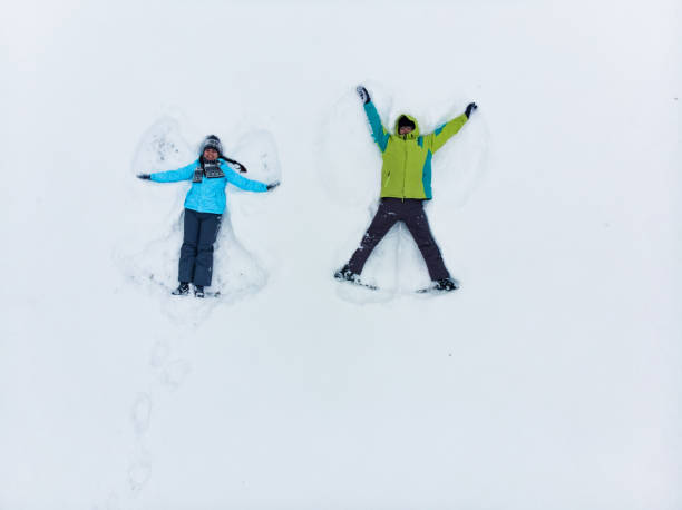 istock couple having fun making snow angel 1197995941