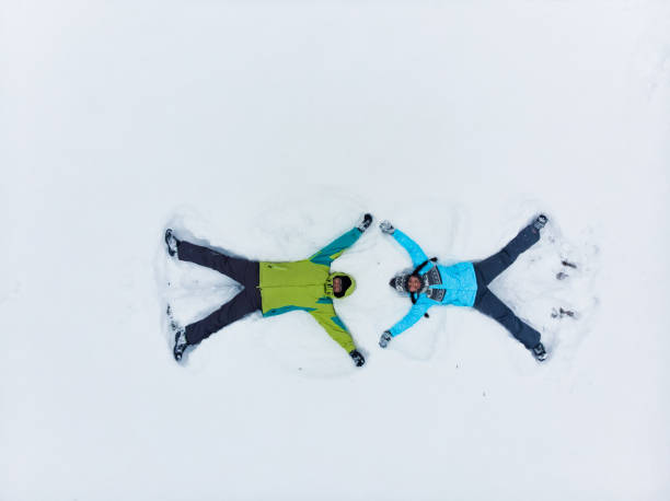 istock couple having fun making snow angel 1197995945
