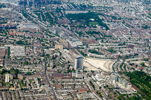 Aerial view looking north across Earls Court and Holland Park districts of central London on a sunny morning.  The Empress State Building is towards the middle.