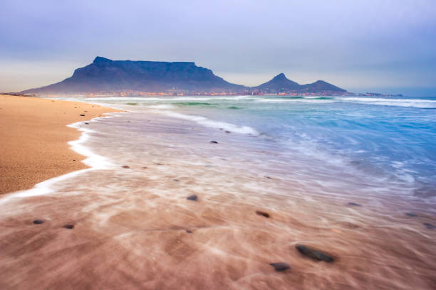 vista da montanha da tabela no nascer do sol da praia de milnerton, cidade do cabo, áfrica do sul - milnerton - fotografias e filmes do acervo