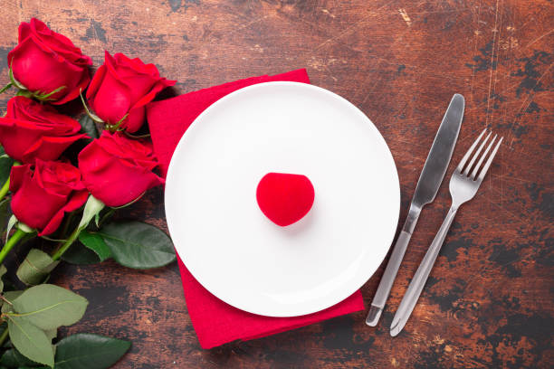 istock Valentines day table setting empty plate, red roses and velvet ring box on wooden background. Top view. Valentine's greeting card 1197998383
