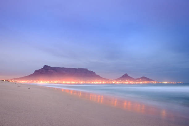 view of table mountain at sunrise from milnerton beach, cape town, south africa - milnerton imagens e fotografias de stock