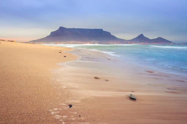 view of table mountain at sunrise from milnerton beach, cape town, south africa - milnerton imagens e fotografias de stock