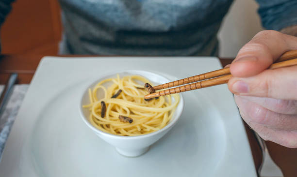 istock Man eating spaghetti and crickets 1198004394