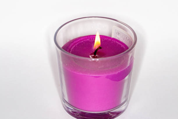 istock A pink Christmas candle burns on a white background. 1198006853
