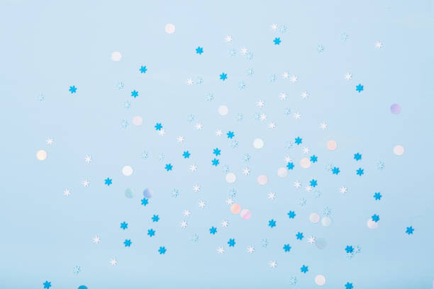 istock Little snowflakes confetti on blue background 1198009426