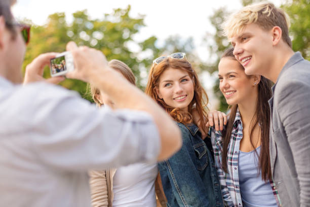 istock teenagers taking photo outside 1198010725