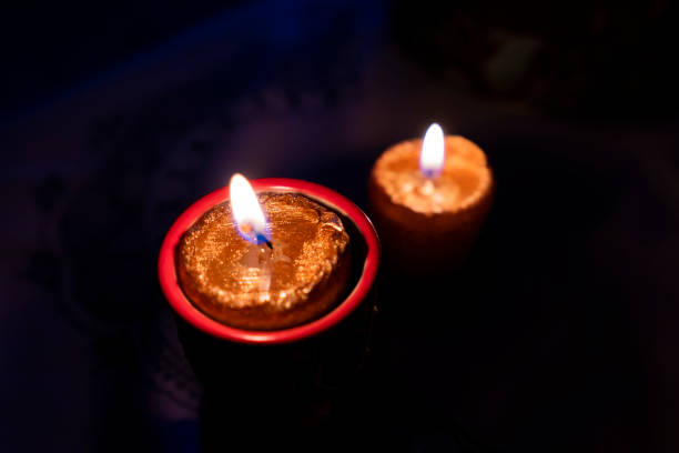 istock Two gold candles with black background 1198013074