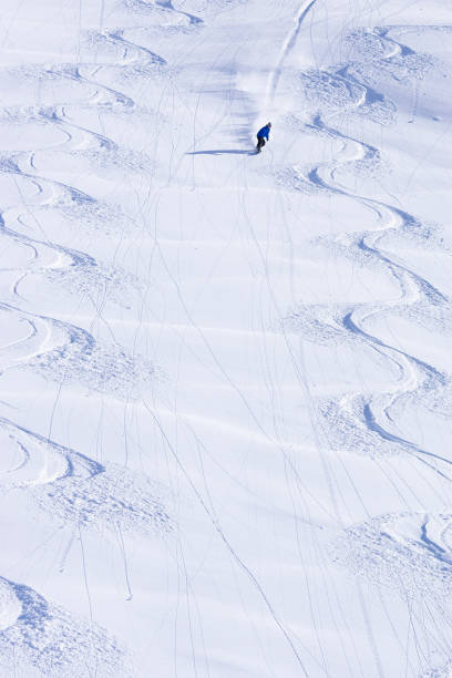 Skiers going down the slope at high speed