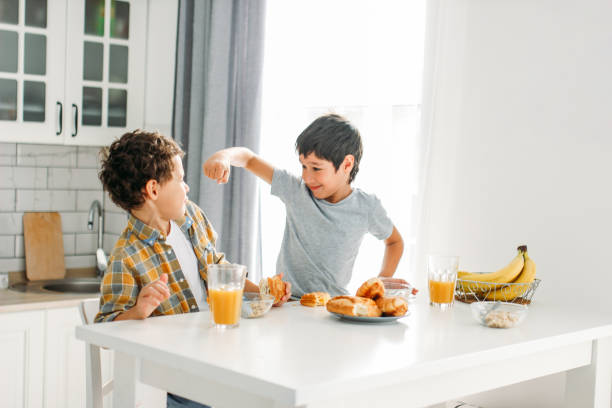 istock Two siblings tween boys real brothers fight at breakfast table on bright kitchen at home 1198015486