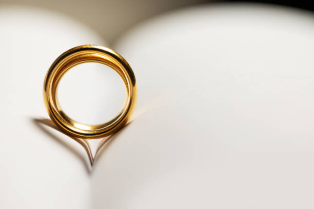 istock Golden wedding rings on book 1198015546