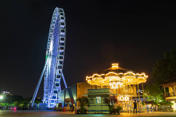 Bangkok ,Thailand - 2019 December 04 : Ferris wheel and carousel against back sky in Asiatique The Riverfront (Bangkok), Asiatique: The Riverfront is a large open-air mall in Bangkok, Thailand.