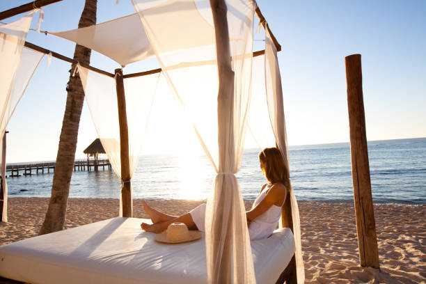 istock woman on the beach lying on a bed 1198017296