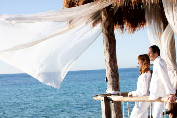 istock couple in a bungalow on the sea 1198018031