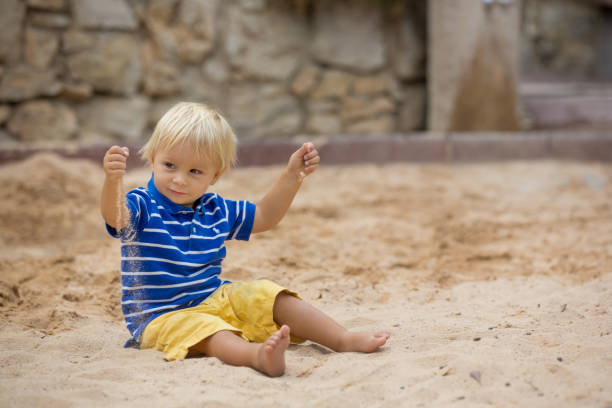istock Little toddler boy, playing with sand in sandpit at the playground 1198018135