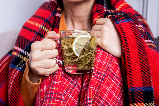 istock Woman feeling freeze and wrap up in a blanket. 1198020672