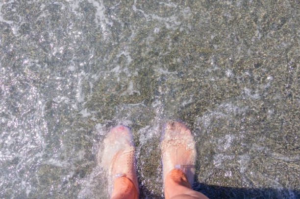 istock Female feet in protective rubber slippers for walking on corals. Top view 1198022715