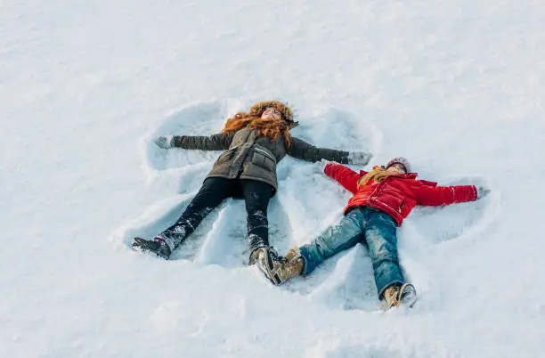 Photo of Full length of girls making snow angels