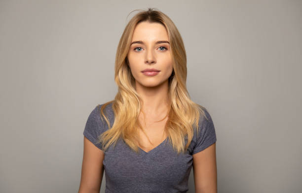 Real woman. Close up photo of a charming girl with fair hair, who is looking in the camera with calm facial expression. blonde hair stock pictures, royalty-free photos & images